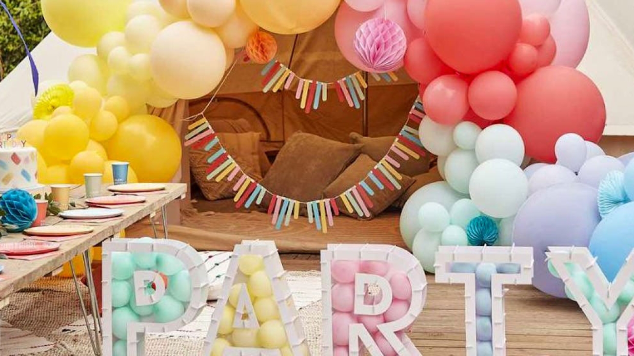Summer party with colourful balloons and letters spelling out party