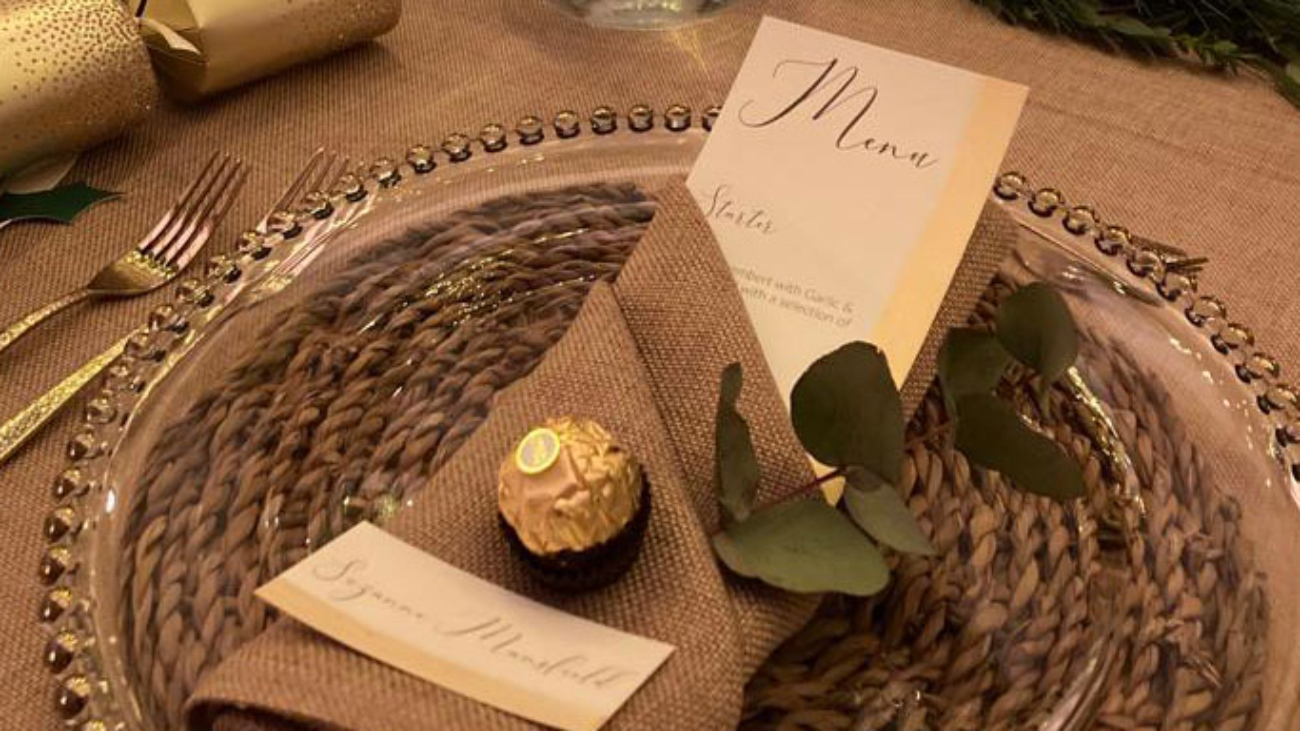 Dinner setting with a personalised name card with a napkin folded around it
