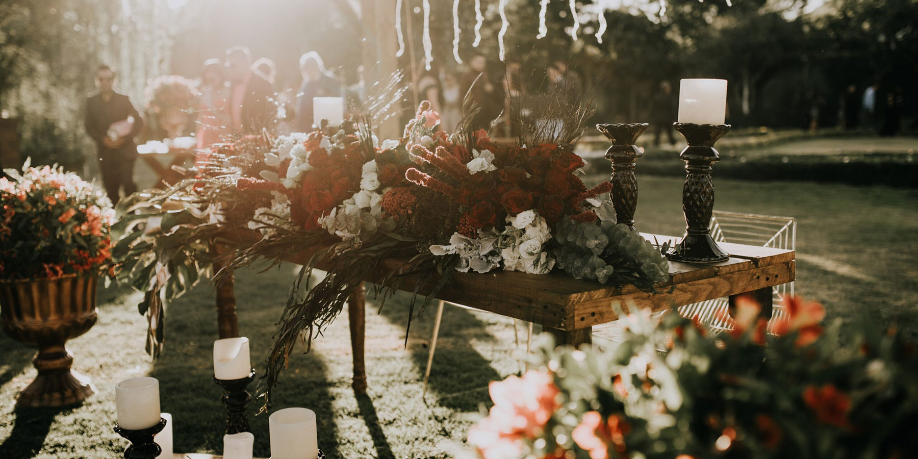 An outdoor table covered in floral arrangements