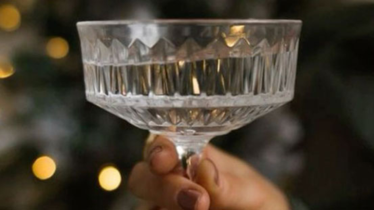 A hand holding a cocktail glass