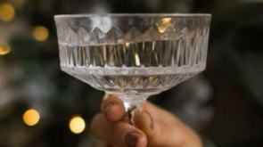 A hand holding a cocktail glass