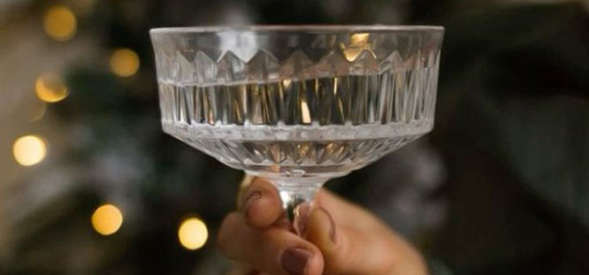 A hand holding a cocktail glass