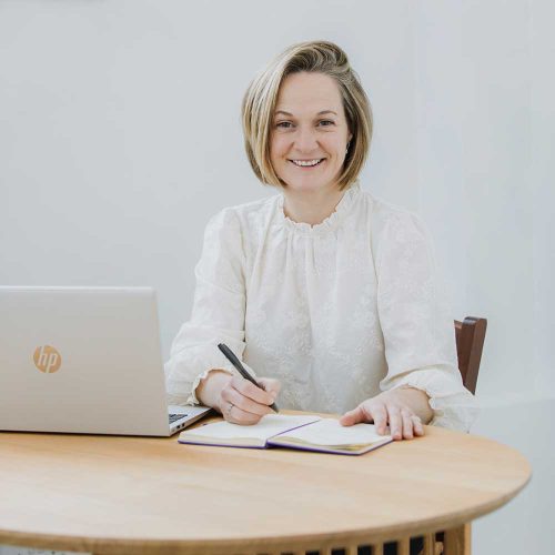 Lucy Hall of Lucy Claire Events sat at a desk with her laptop